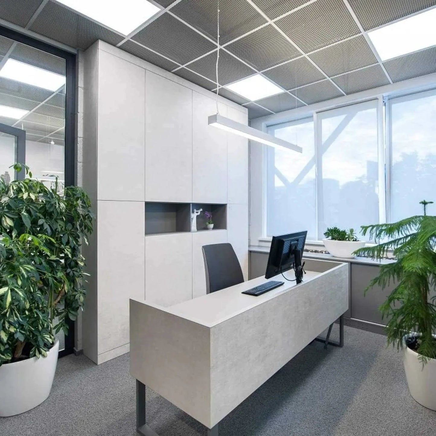 Esnco 60W LED Panel Light hanging over an office desk in a modern white interior.