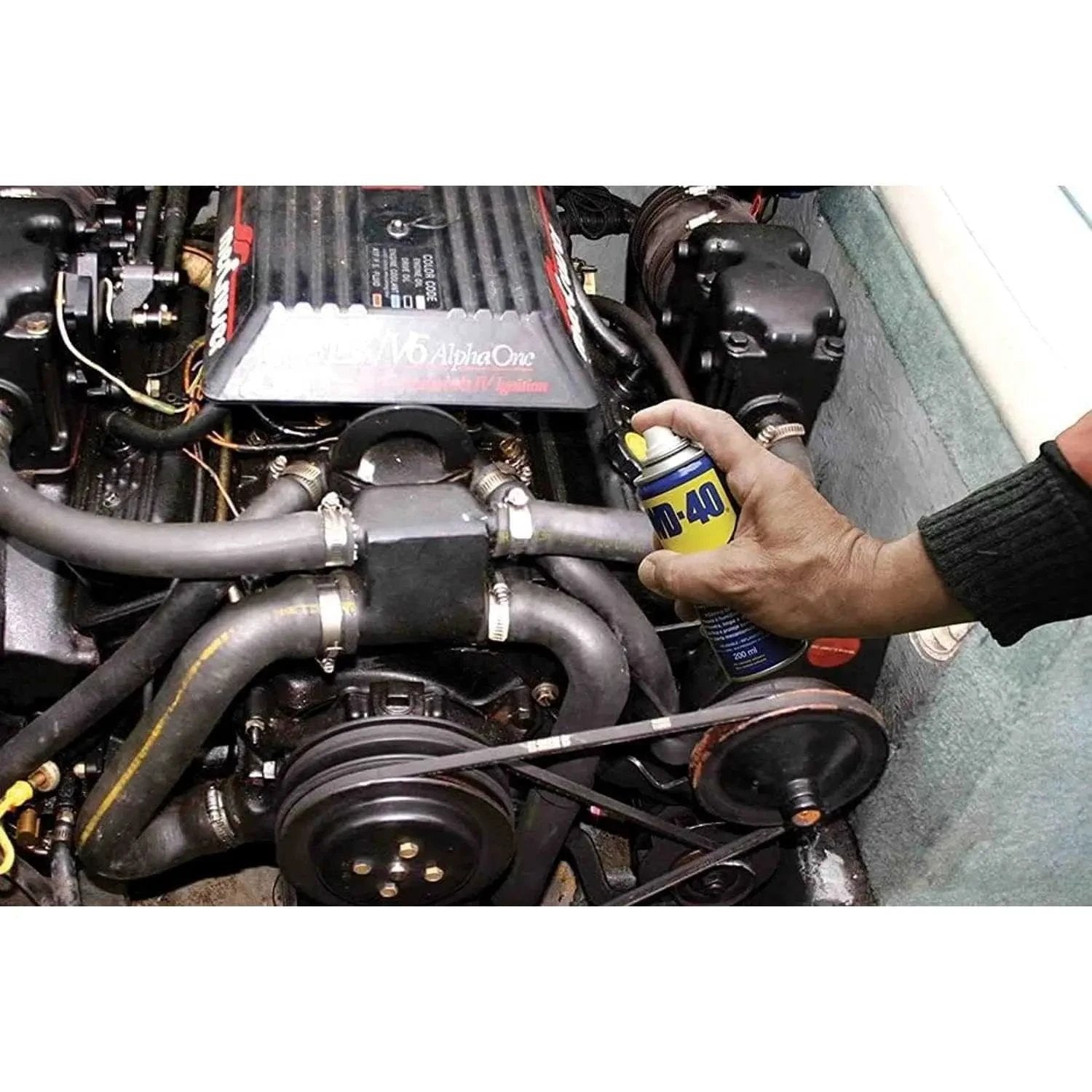WD-40 Multi-Use Product Original Rust Remover 330ml spray can held in hand beside a car engine bay. UAE